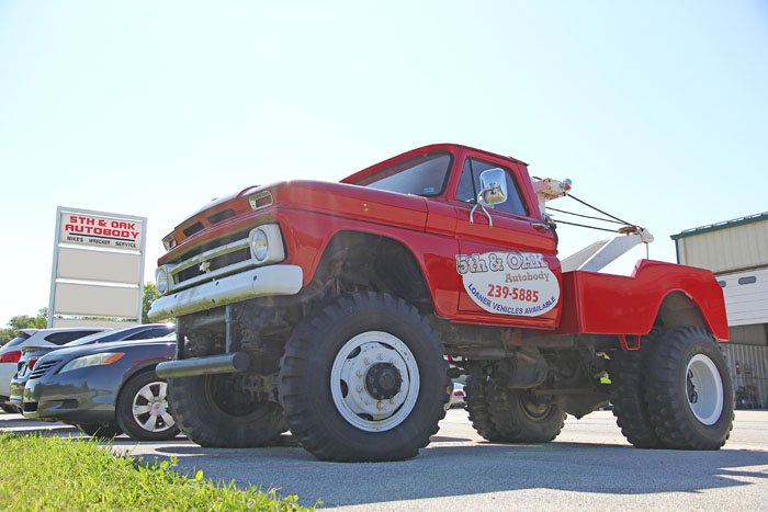 5th & Oak Autobody's vintage red tow truck parked outside the shop in Washington, Missouri